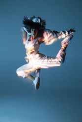 Energetic dancer jumping and looking at camera