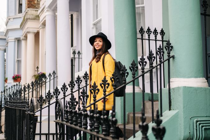 Cheerful woman standing in stairs in typical london buildings