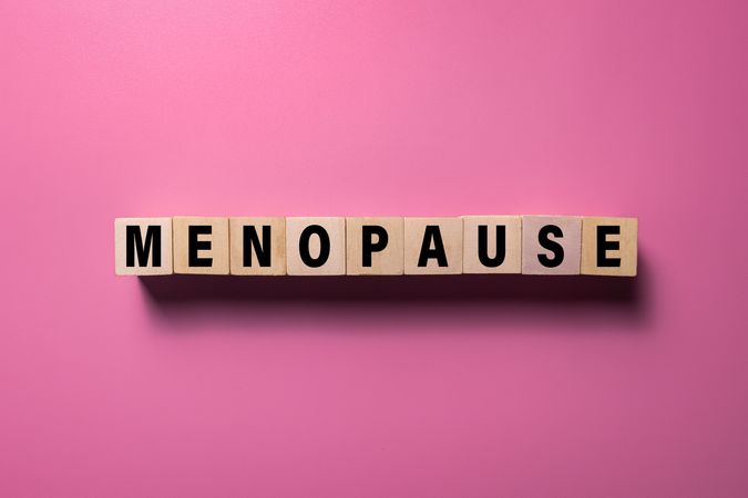 menopause words text on wooden blocks isolated on pink background