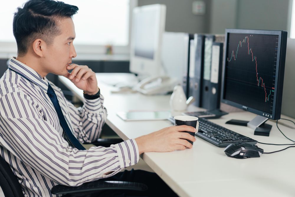 Man engrossed in chart on computer at work