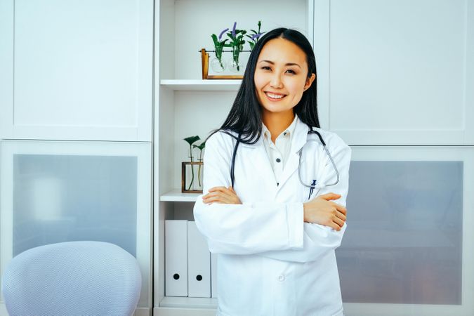 Confident smiling Asian woman doctor at work
