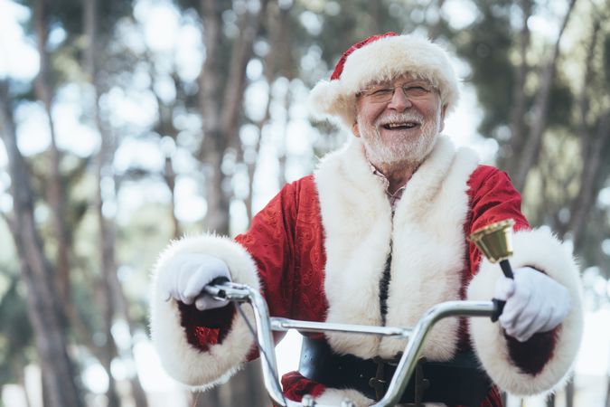 Happy Santa Claus riding bicycle by van
