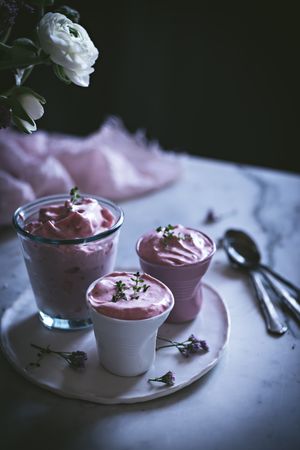 tasty glasses of strawberry mousse on a table with flowers