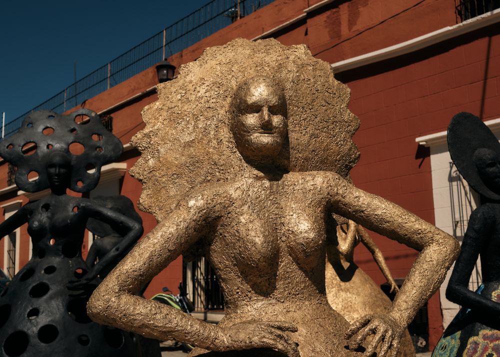 Golden statue of woman with sun rays around head