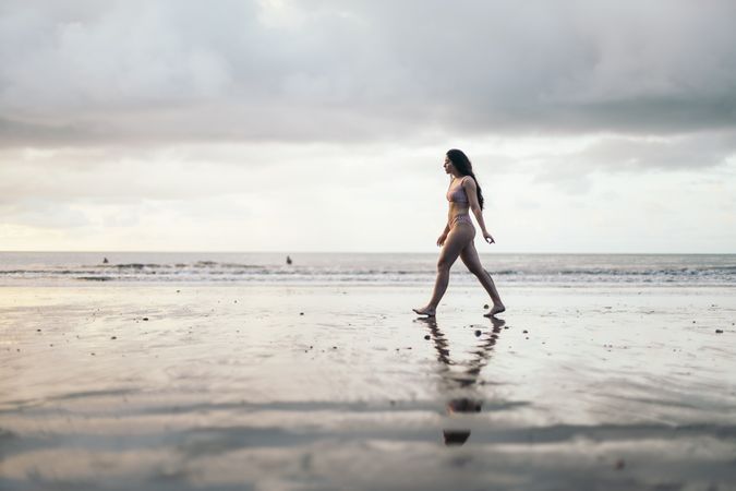 woman walking on the beach at sunset