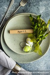 Easter concept with branch and green decorative eggs on grey ceramic plates 5zrZGP