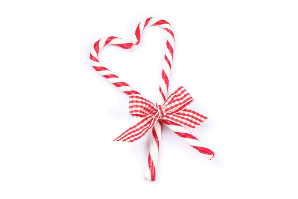 Sweet candy canes with bow isolated on blank background