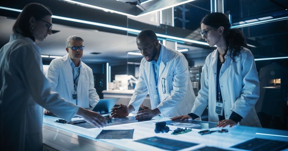 Diverse Team of Industrial Robotics Specialists Working on Innovative Prosthetic Hands in a Research Facility.