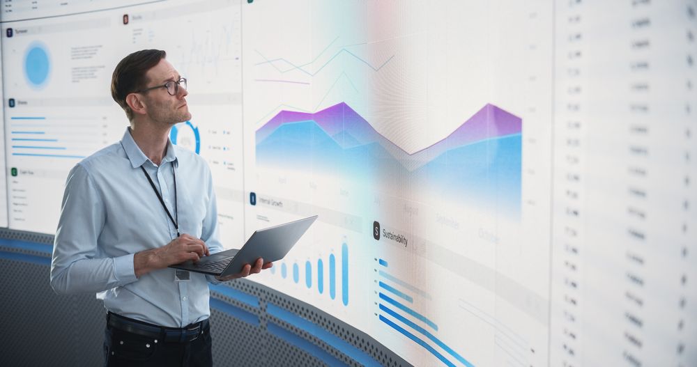 Successful Man Reviewing Financial Reports For Investment Management Company.