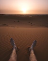 Crop legs of traveler on sandy dune