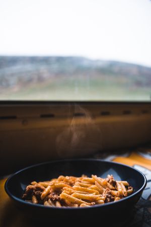 Mug with fresh pasta near window