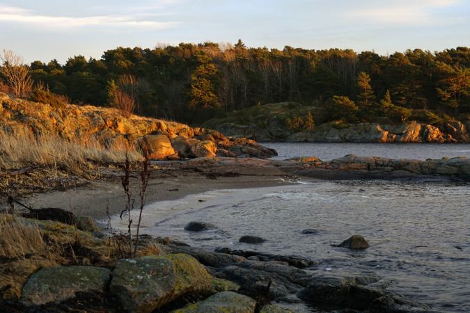 Rocky shore of tranquil sea in dusk