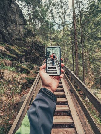 Tourist taking photo while walking on footpath