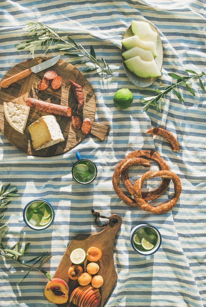 Summer picnic spread with pretzels, mojitos, meat and cheese board