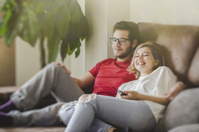 Happy couple watching TV on sofa