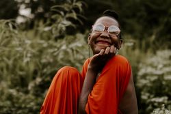 Woman in orange dress wearing glasses