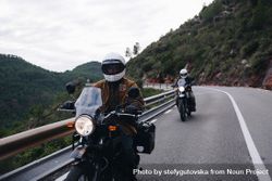 Two bike riders traveling on winding road 0Kp1D5