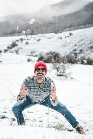 Man playing with snow on winter field