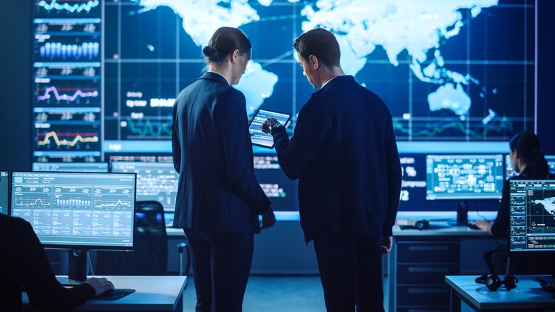 Experts Collaborate in a High-tech Control Room, Analyzing Data on Multiple Screens to Enhance Cybersecurity Strategies and Global Insights. the Environment Fosters Innovation and Strategic Decision-making.