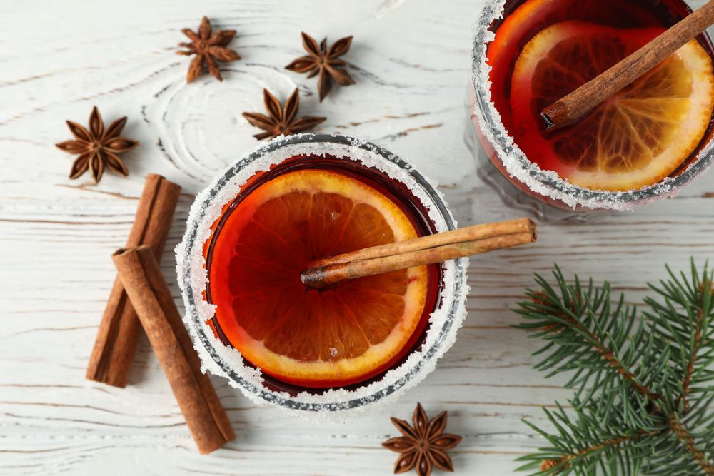 Glasses of tasty mulled wine on wooden background, top view
