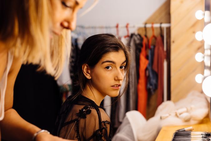 Makeup artist doing makeup for young female artist
