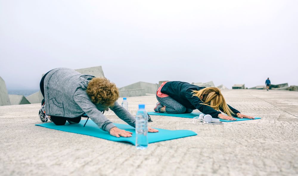 Unrecognizable young and Older woman stretching back outdoors