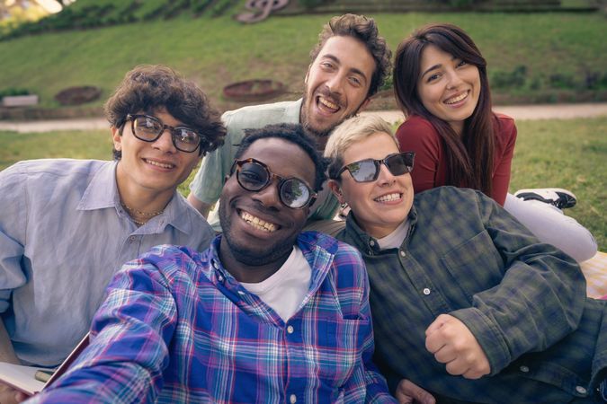 Happy diverse group of friends taking a point of view selfie outdoors.
