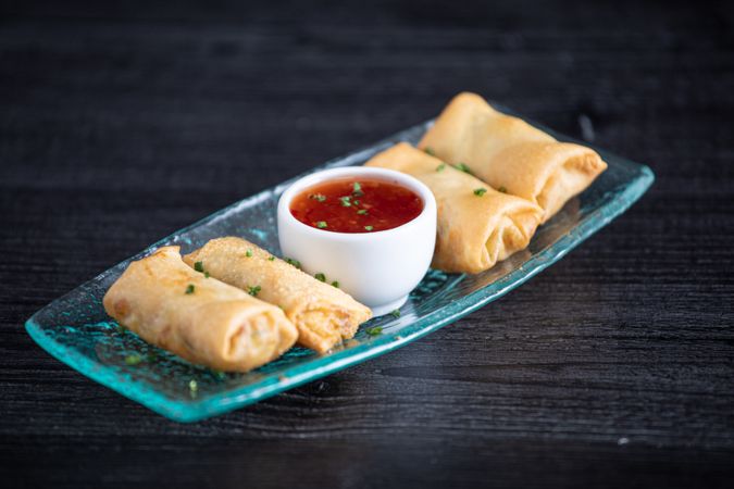 Vietnamese rolls with sweet chili on glass plate