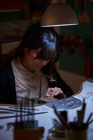 Professional female jewelry maker working in studio