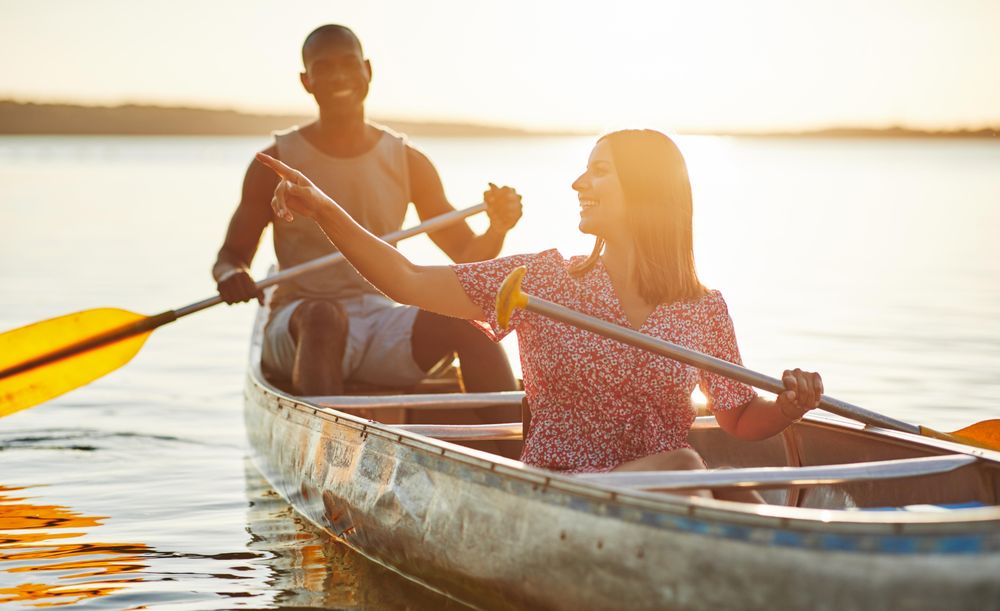 Two people canoeing at sunset