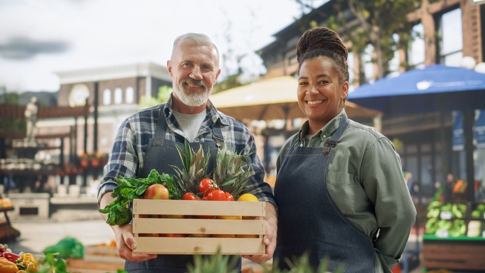Portrait of a Happy  Multiracial Street Vendors Couple Posing for Camera and Smiling.