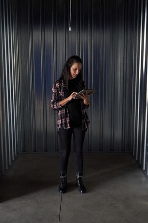 Woman browsing tablet in container