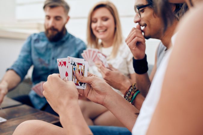 Group of friends sitting together playing cards