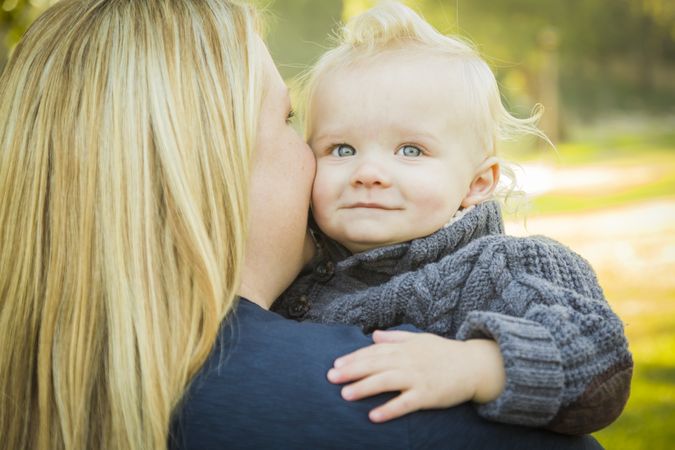 Mother Embracing Her Adorable Blonde Baby Boy.