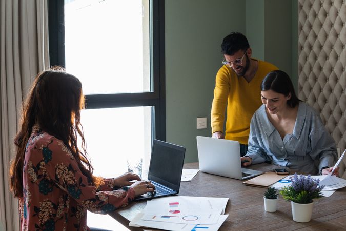 Focused colleagues working on laptops in coworking space