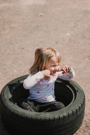 Little girl sitting inside tire