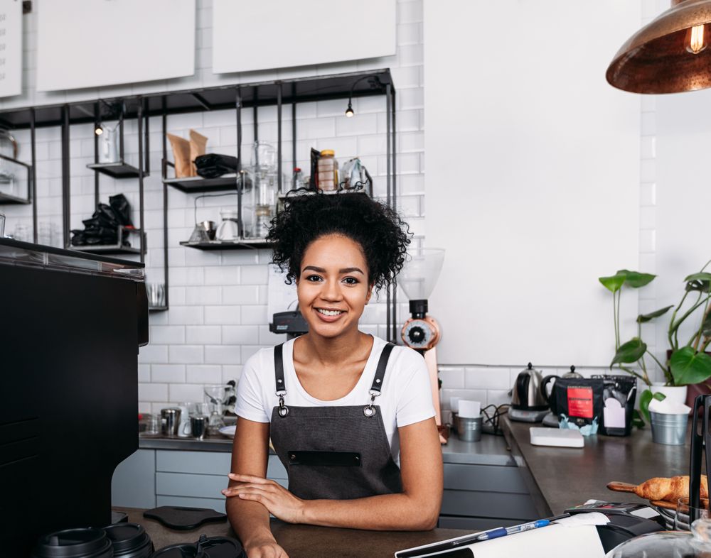 Happy cafe owner smiling at counter