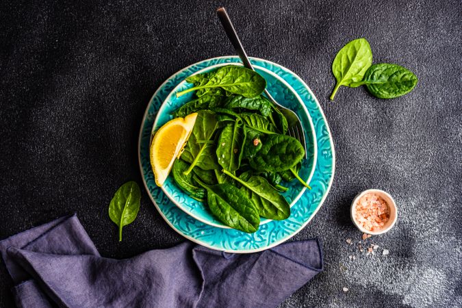 Looking down at spinach salad with lemon slice