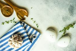 Top view of salt and pepper shakers, thyme and garlic on marble background with copy space