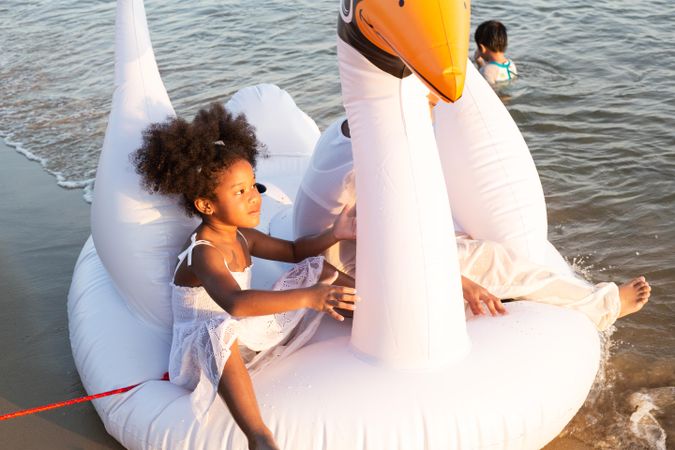 Two sisters playing in the water with inflatable ring