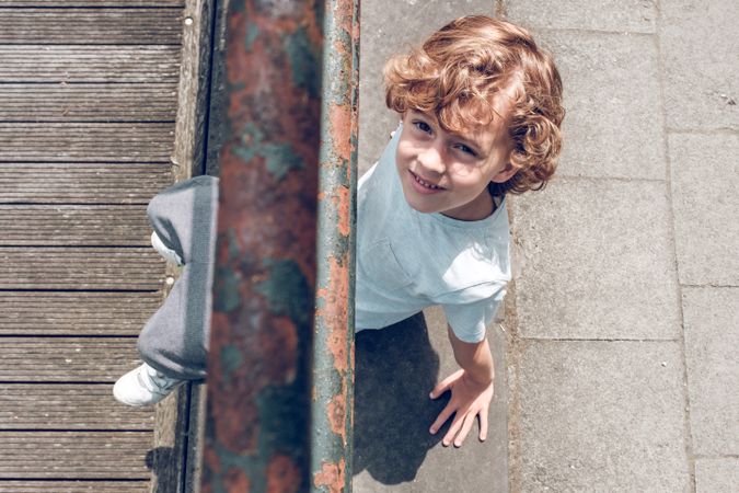 Smiling boy sitting on asphalt road