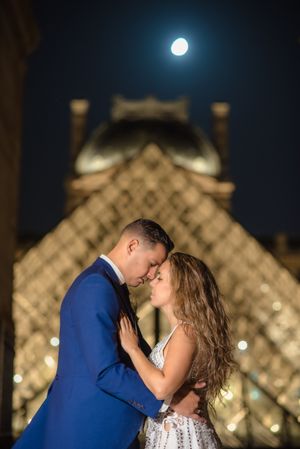 Just married couple in wedding clothing cuddling under moonlight