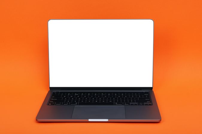 Laptop with mockup screen in orange studio shoot