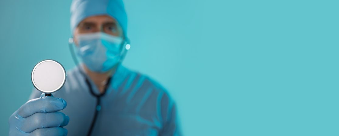 Doctor Holding Stethoscope Looking at Camera Banner