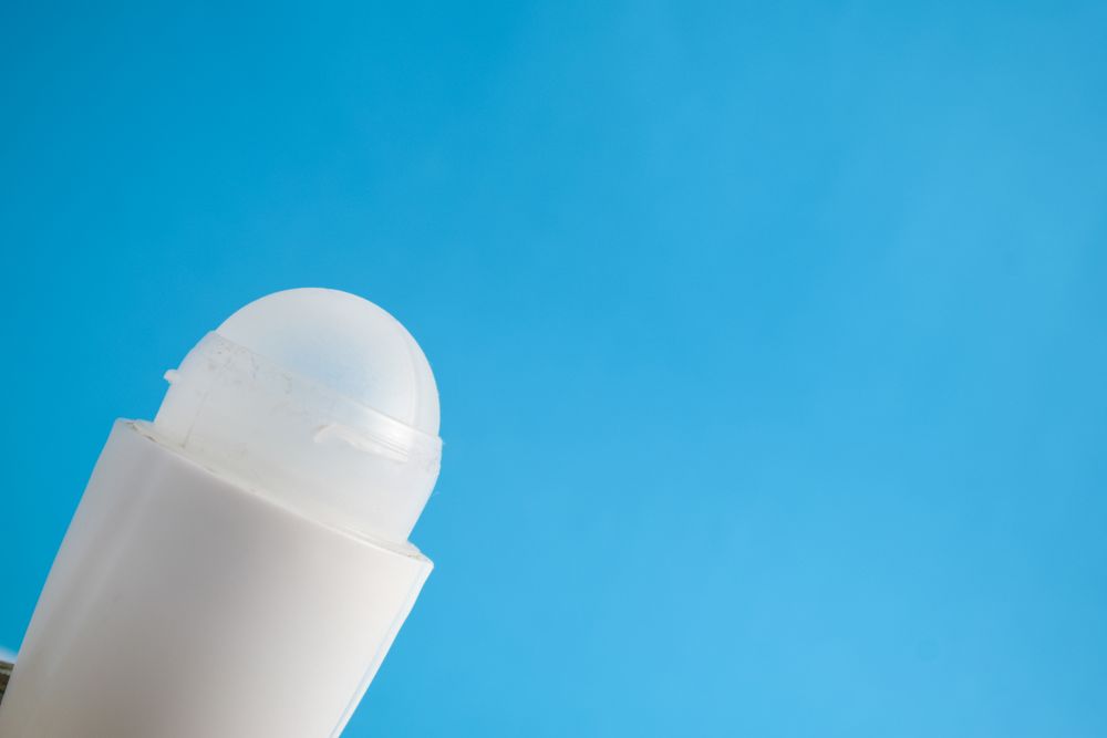 Deodorant bottle on blue background