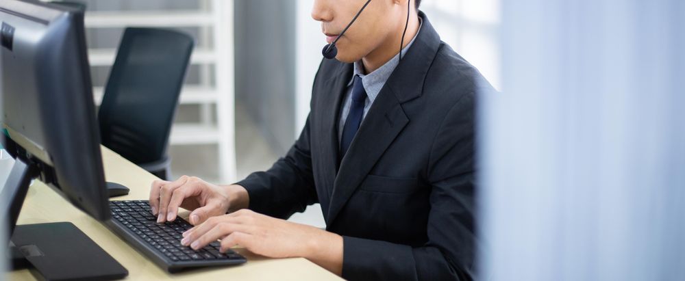 Man at work wearing headset, banner orientation