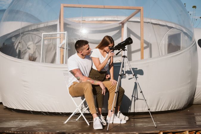 Young couple using astronomical telescope