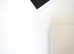 Looking down at laptop and phone on bright desk
