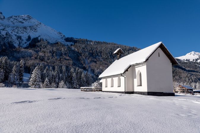 Sunny winter landscape with church minimalist in snow-covered nature