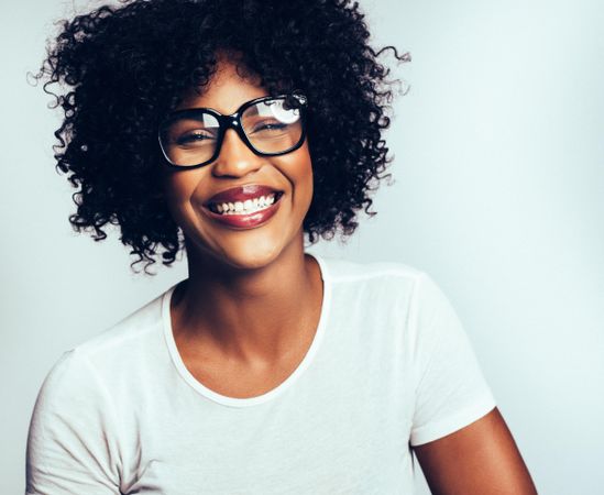 Studio portrait of laughing woman in large glasses